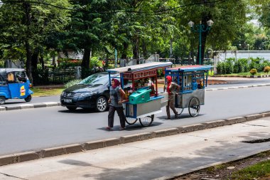 Endonezyalı kadınlar sokakta seyyar gıda tezgahı taşıyorlar, Jakarta.