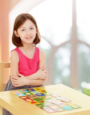 küçük kız kartları masaya bırakır.