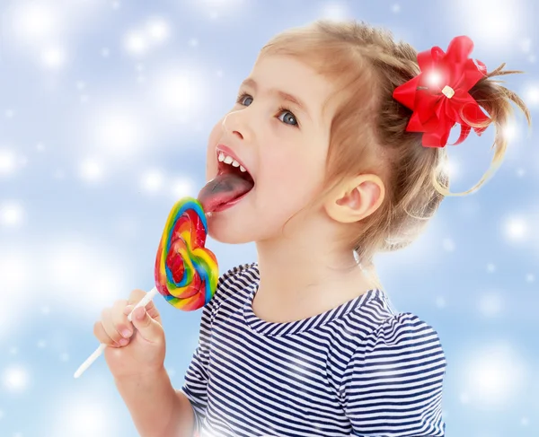 Girl licks candy on a stick — Stock Photo, Image