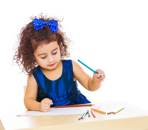 Mała dziewczynka rysuje się przy stole z ołówki — Zdjęcie stockowe