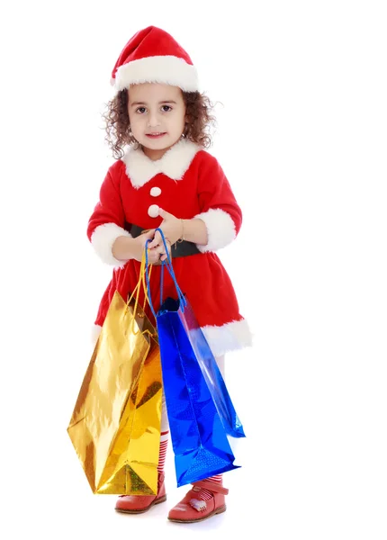 Little girl in costume of Santa Claus with colorful packages — Stock Photo, Image