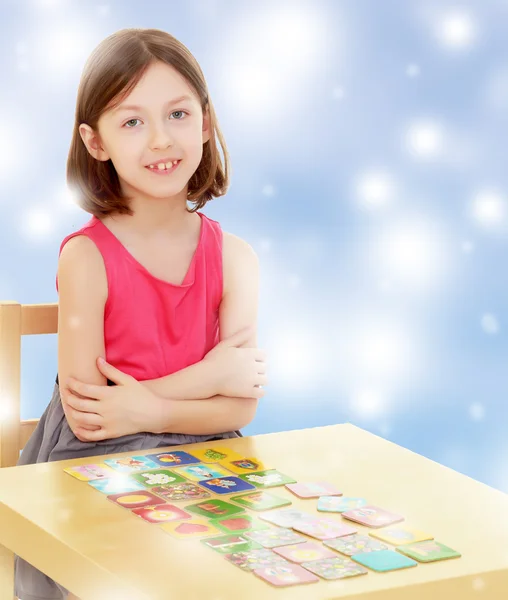 Liten flicka lägger korten på bordet — Stockfoto