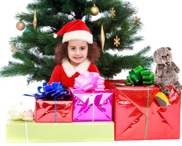 Little girl near the Christmas tree surrounded by gifts — Stock Photo, Image