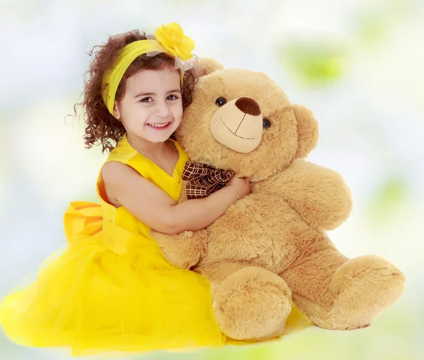Маленька дівчинка обіймає плюшевого ведмедя — стокове фото