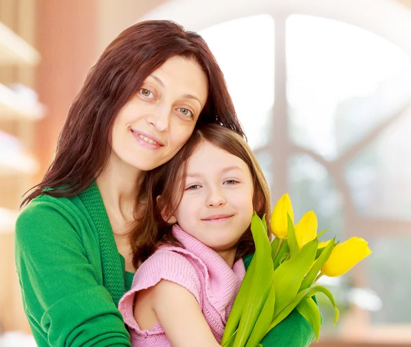 Retrato de mãe e filha com um buquê de tulipas . — Fotografia de Stock