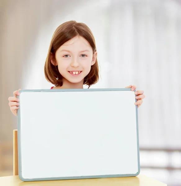 Little girl holding white poster. Stock Picture
