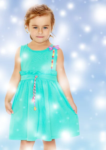 Beautiful little tanned girl in a blue dress. — Stock Photo, Image