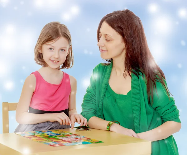 Läraren och flickan på tabellen studera korten — Stockfoto