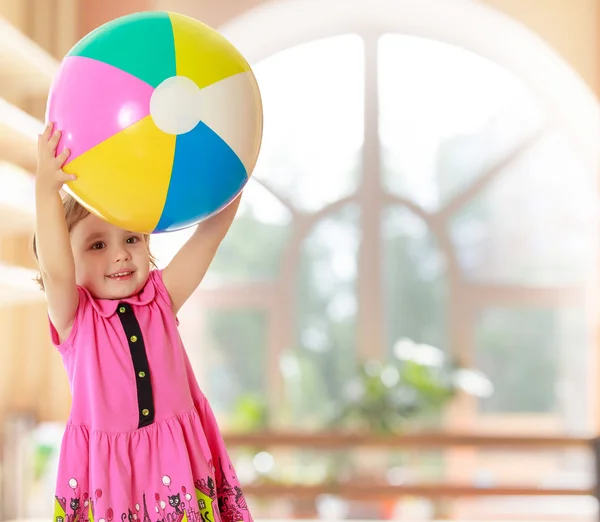 Mädchen hält Ball über Kopf — Stockfoto