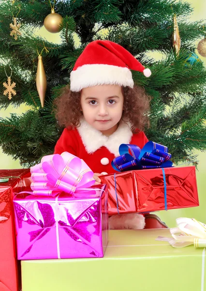 Mała dziewczynka w pobliżu choinki w otoczeniu prezentów — Zdjęcie stockowe
