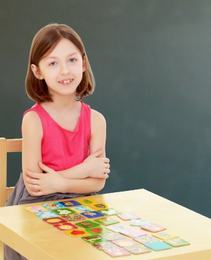 küçük kız kartları masaya bırakır.