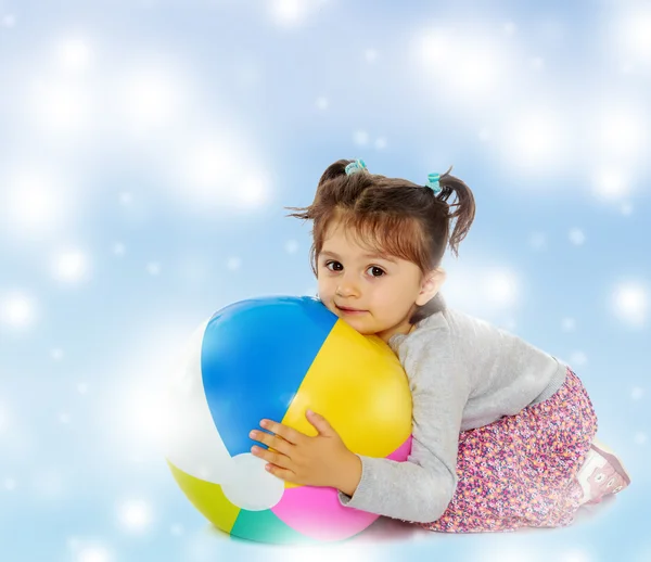 Маленькая девочка обнимает большой мяч — стоковое фото