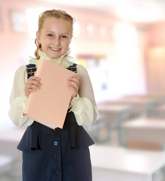 Flicka skolan i en svart klänning och bok i händerna. — Stockfoto