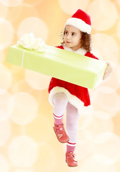 Маленькая девочка в костюме Санта-Клауса с подарком — стоковое фото