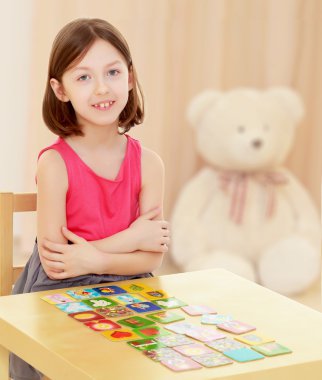 küçük kız kartları masaya bırakır.