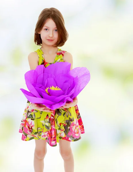 Bambina che tiene un grande fiore viola — Foto Stock
