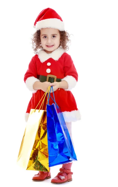 Bambina in costume di Babbo Natale con pacchetti colorati — Foto Stock