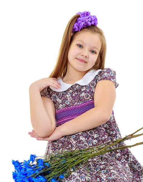 Beautiful little girl with a bouquet of blue flowers — Stock Photo, Image