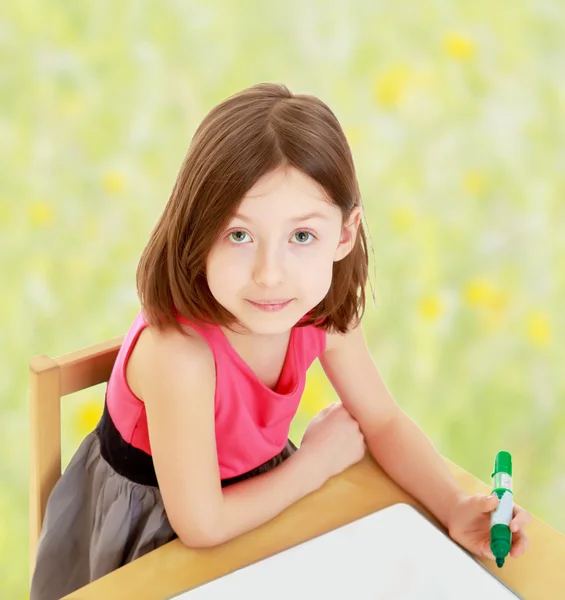 Küçük kız keçeli kalem beyaz bir yüzeye çizer.. — Stok fotoğraf