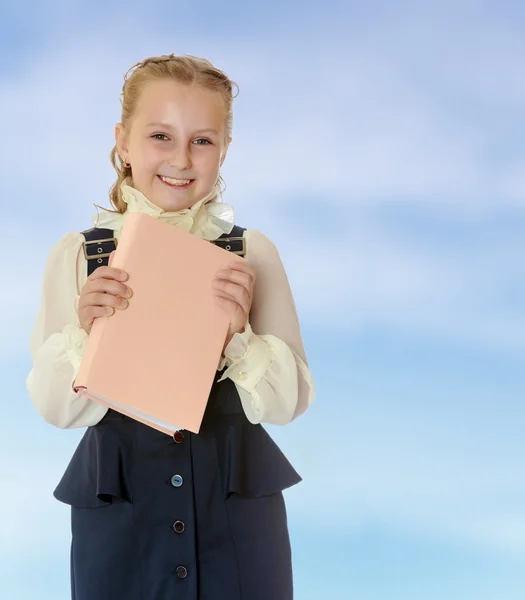 Chica de la escuela en un vestido negro y libro en sus manos . — Foto de Stock