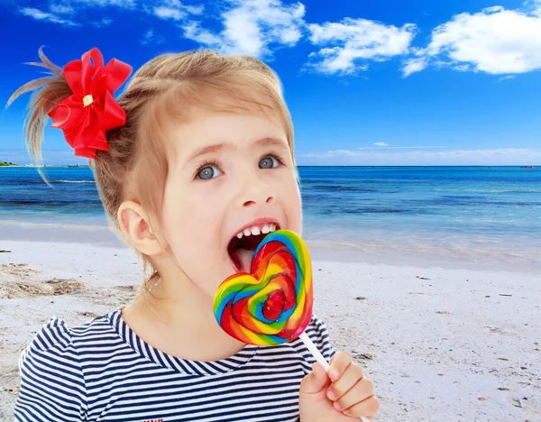 Meisje likt snoep op een stick — Stockfoto