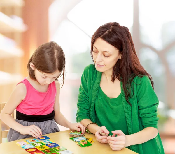 Mamma och dotter vid bordet spelar pedagogiska spel — Stockfoto