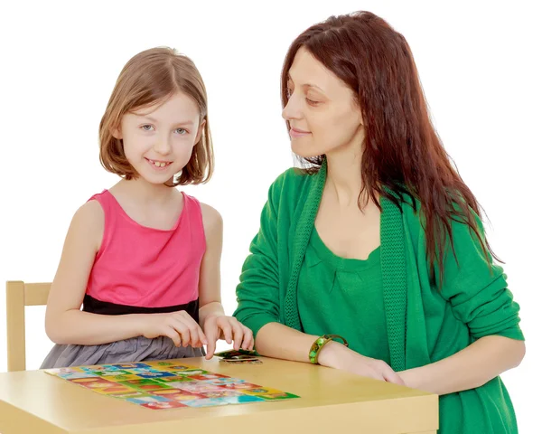 The teacher and the girl at the table studying the cards — Stock Photo, Image