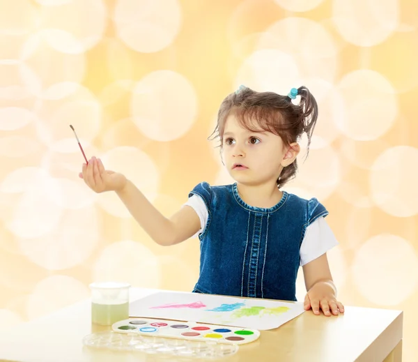 小女孩涂料用水彩在桌. — 图库照片