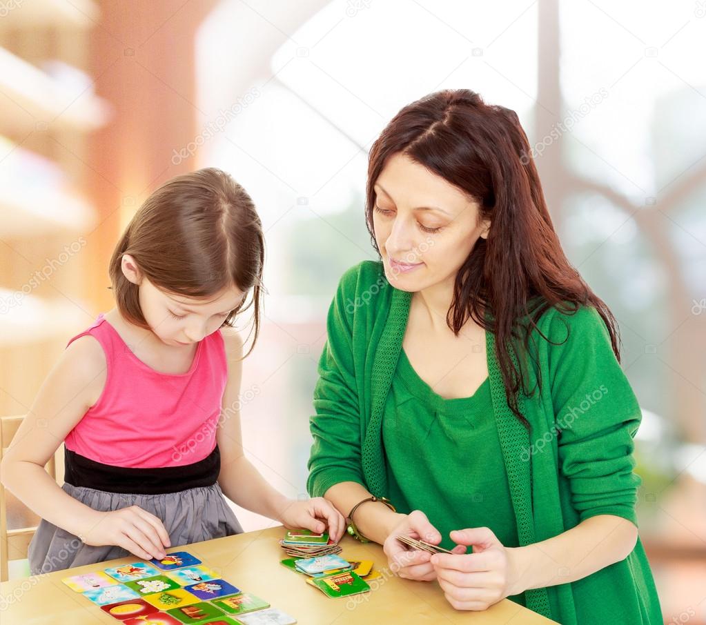 Mom and daughter at the table playing educational games