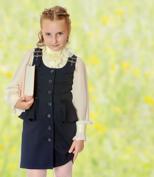 Flicka skolan i en svart klänning och bok i händerna. — Stockfoto