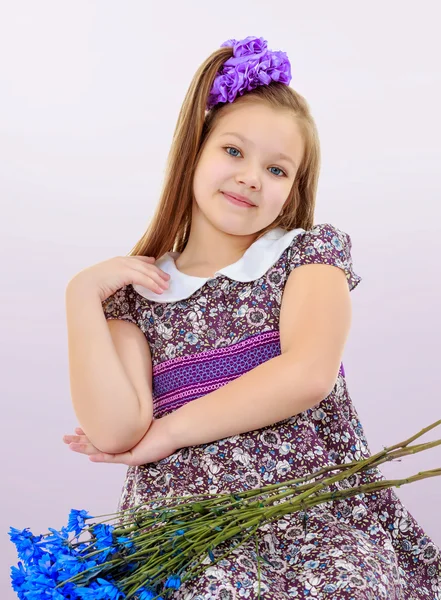 Menina bonita com um buquê de flores azuis — Fotografia de Stock