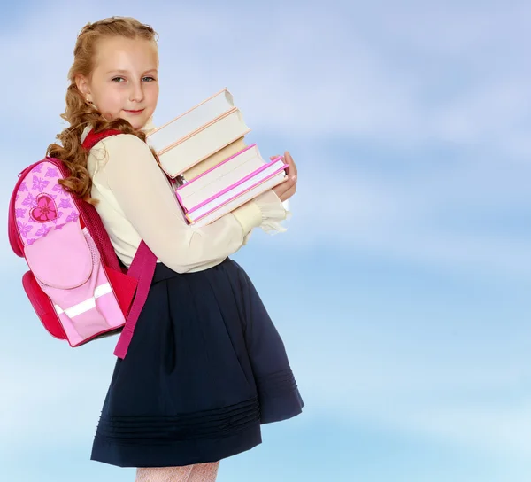 Κορίτσι μαθήτρια με μια τσάντα πίσω από τους ώμους και τα βιβλία σε han — Φωτογραφία Αρχείου