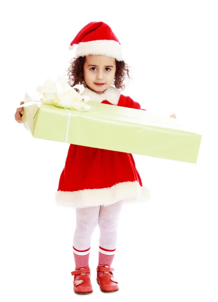 Klein meisje in kostuum van de kerstman met cadeau — Stockfoto