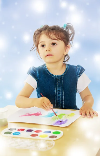 Niña pinta con acuarelas en la mesa . — Foto de Stock