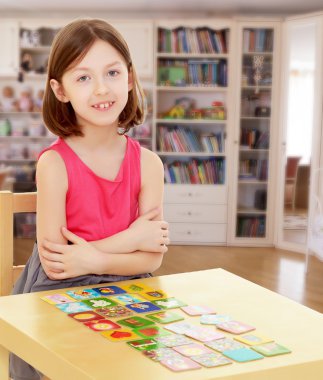 küçük kız kartları masaya bırakır.