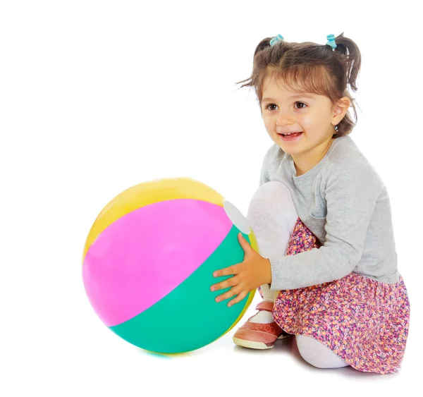 Malá holčička objímání velký míč — Stock fotografie