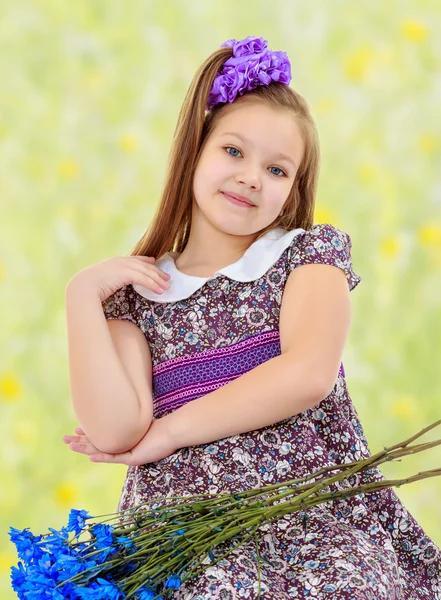 Belle petite fille avec un bouquet de fleurs bleues — Photo