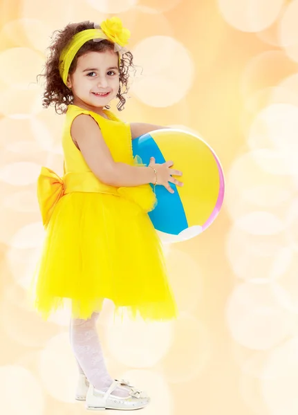 Bambina in abito giallo con grande palla — Foto Stock