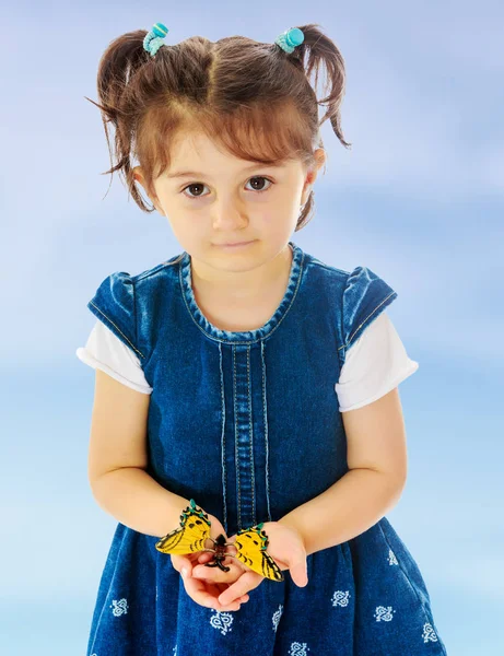Bambina stretta nelle mani di una grande farfalla . — Foto Stock