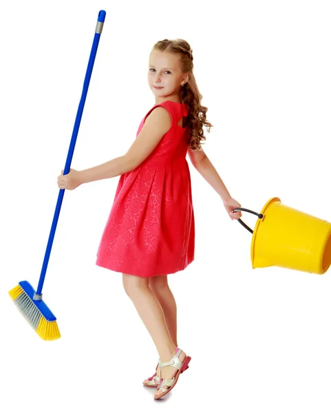 Little girl with bucket and brush cleans the house. Stock Photo