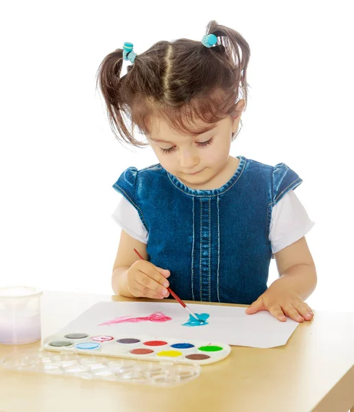 Küçük kız masada suluboya ile boyar. — Stok fotoğraf