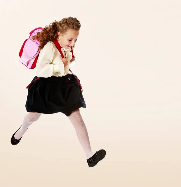 Menina com mochila e corre para a escola . — Fotografia de Stock