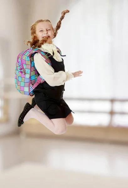 Дівчина школярка з сателітом за плечима стрибає — стокове фото