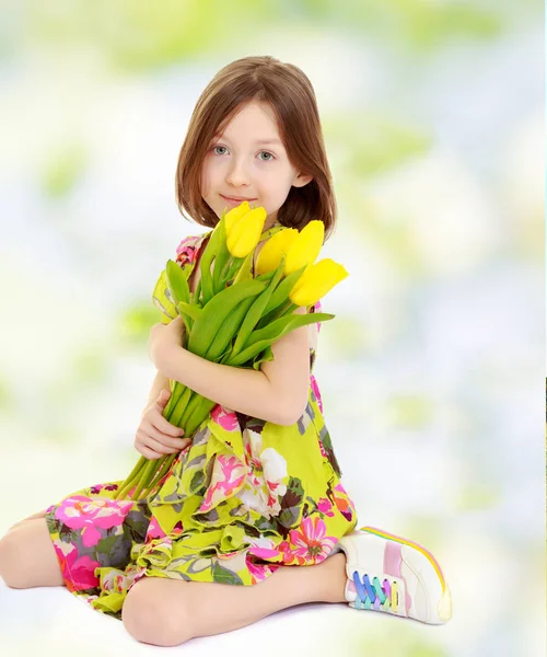 Menina com um buquê de tulipas amarelas . — Fotografia de Stock