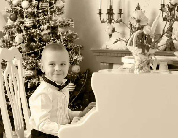 Un ragazzino è seduto al pianoforte — Foto Stock