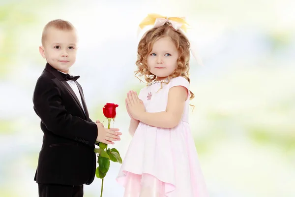 El niño le da a la niña una flor. . — Foto de Stock