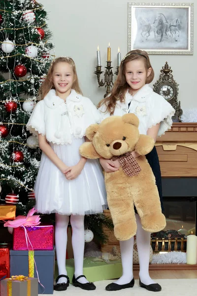 Дівчата близнюки з подарунками е Різдвяна ялинка . — стокове фото