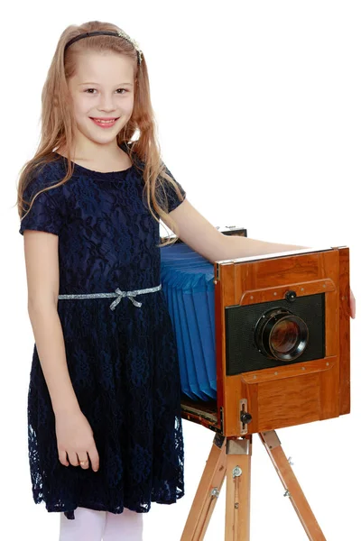 The girl looks at the old camera. — Stock Photo, Image