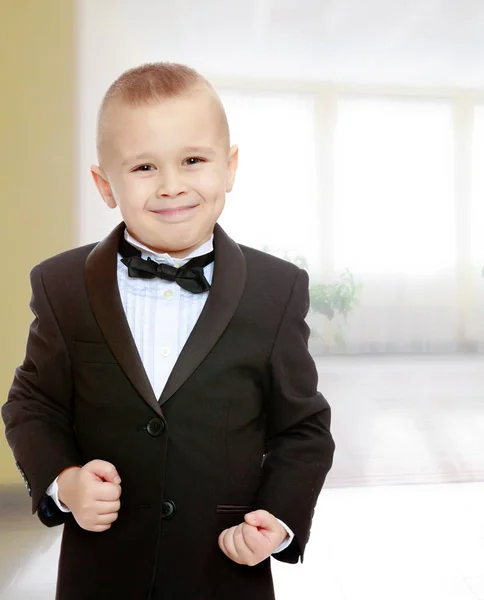 Trendy little boy in a black suit with a tie. — Stock Photo, Image