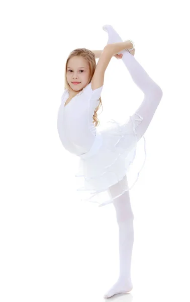 Malá gymnastka opatrně ohýbá těla. — Stock fotografie